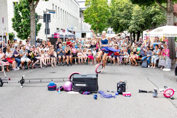 Eine Straßenkünstlerin fährt vor Publikum auf ihrem Einrad