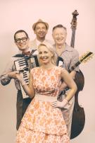 das Quartett ist mit ihren Instrumenten freudig und lässig auf dem Bild zu sehen.