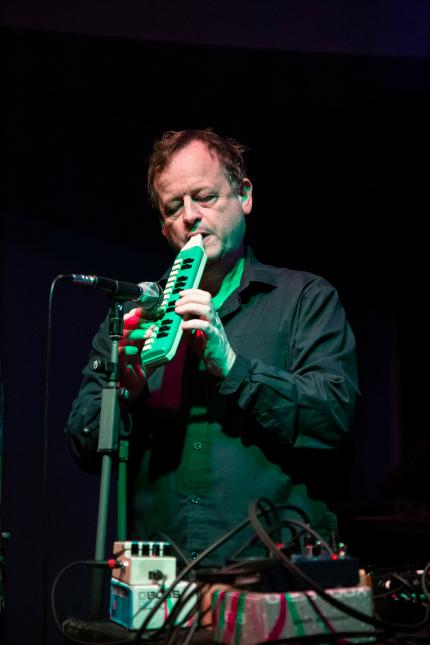 Eine männlich gelesene Person spielt Melodica.