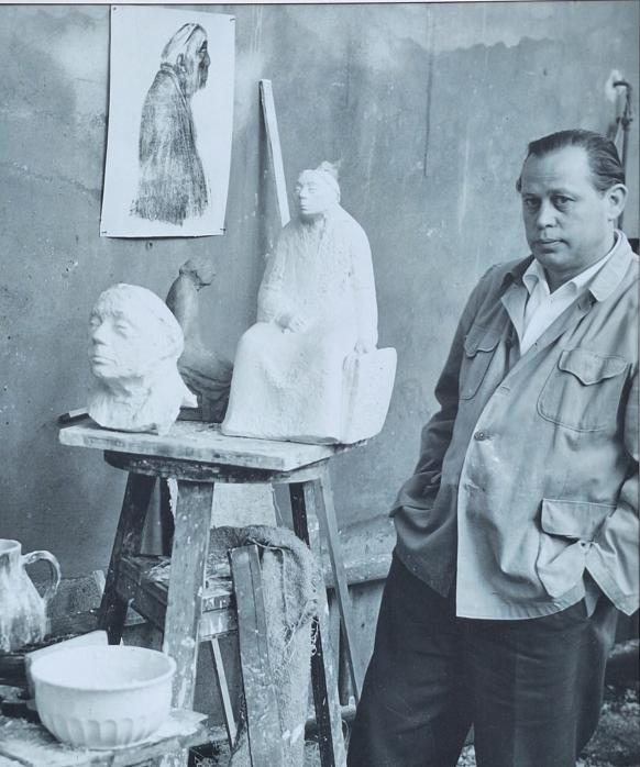 Zu sehen ist Gustav Seitz in seinem Außenatelier in Berlin-Pankow mit Gipsmodellen zum Kollwitz-Denkmal