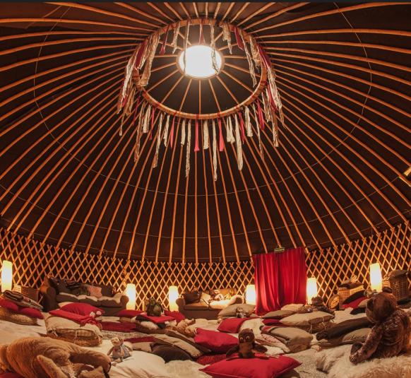 die Jurte innen - Kissen und Teppiche mit Kuscheltieren auf dem Boden