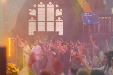 Foto von einer jubelnden, tanzenden Menge junger Menschen in der Kirche