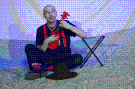 Peter Wachter sitzt mit Ukulele auf dem Boden