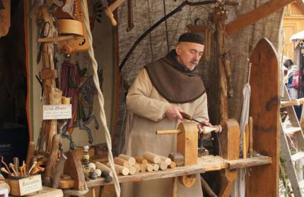 Drechsler in mittelalterlichem Gewand beim Drechseln