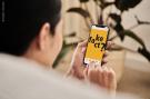 Eine Person die ein Smartphone bedient, auf dem der Schriftzug "Fake Fact?" in schwarzer Schrift auf gelbem Grund abgebldet ist.