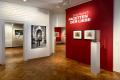 Das Bild zeigt einen Blick in die Ausstellungsr&auml;ume der Ausstellung "Ernst Barlach. Facetten der Liebe". Man sht eine schwarz-wei&szlig; Fotografie des K&uuml;nstlers an der Wand sowie drei seiner Werke vor einer roten Wand.