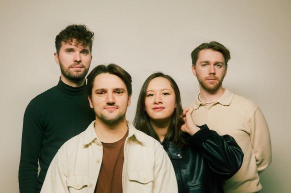 Die vier Musiker blicken in die Kamera.