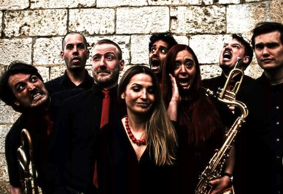 Bandfoto BRASSED ARTS: Die acht Bandmitglieder mit Blechblasinstrumenten